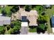 Aerial view featuring mature trees, lush lawns, solar panels, a large patio, and a spacious driveway at 8644 S Brentwood St, Littleton, CO 80128