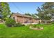Spacious backyard with lush green lawn, mature trees, and stone facade at 8644 S Brentwood St, Littleton, CO 80128
