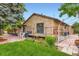 Stone facade exterior with a wood deck, patio and manicured yard at 8644 S Brentwood St, Littleton, CO 80128