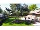 Landscaped backyard featuring a mature tree, patio, green grass and stone facade exterior at 8644 S Brentwood St, Littleton, CO 80128