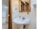 Traditional vanity with a pedestal sink, faucet, and light wood medicine cabinet at 8644 S Brentwood St, Littleton, CO 80128