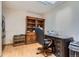 Well-lit home office with built-in shelves, a desk, and an executive chair at 8644 S Brentwood St, Littleton, CO 80128