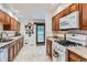 Bright kitchen featuring wood cabinets, white appliances, tile flooring, and a sliding door to the deck at 8644 S Brentwood St, Littleton, CO 80128