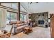 Comfortable living room featuring a stone fireplace, large windows, vaulted ceilings, and cozy furniture at 8644 S Brentwood St, Littleton, CO 80128
