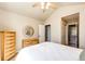Bright bedroom featuring a ceiling fan and adjacent primary bath at 22685 E Calhoun Pl, Aurora, CO 80016