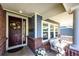 Inviting front porch with brick accents, cozy seating, and decorative details creating a warm entrance at 22685 E Calhoun Pl, Aurora, CO 80016
