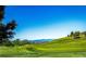 Scenic view of a meticulously maintained golf course with lush green grass and the backdrop of distant mountains at 22685 E Calhoun Pl, Aurora, CO 80016