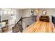 Bright upper hallway featuring wood floors, iron railing, and a cozy sitting area at 22685 E Calhoun Pl, Aurora, CO 80016