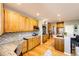 Bright kitchen features wood floors, mosaic backsplash, granite counters, and stainless steel appliances at 22685 E Calhoun Pl, Aurora, CO 80016