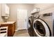 Well-organized laundry room featuring a sink, storage cabinets, and modern washer and dryer set at 22685 E Calhoun Pl, Aurora, CO 80016