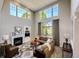 Bright living room with high ceilings, fireplace, and large windows overlooking backyard at 22685 E Calhoun Pl, Aurora, CO 80016