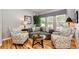 Cozy living room featuring patterned chairs, a comfortable sofa, and a glass-topped coffee table on wood floors at 22685 E Calhoun Pl, Aurora, CO 80016