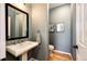 Clean powder room with pedestal sink, wood-look flooring, and stylish decor at 22685 E Calhoun Pl, Aurora, CO 80016