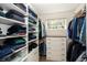Custom walk-in closet with shelving, drawers, and a window for natural light at 22685 E Calhoun Pl, Aurora, CO 80016