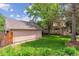Spacious backyard features lush lawn, mature trees, and a detached garage at 1459 S Elizabeth St, Denver, CO 80210