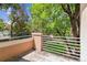Private balcony with neutral stucco and white horizontal railings offers a view to the lush backyard at 1459 S Elizabeth St, Denver, CO 80210