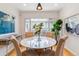 Bright dining area with a round marble table, upholstered chairs, and modern lighting at 1459 S Elizabeth St, Denver, CO 80210