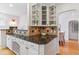 Kitchen area with granite countertops, decorative tiling, glass shelves and adjacent dining room at 1459 S Elizabeth St, Denver, CO 80210