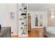 Open-concept living area with built-in shelving, hardwood floors, and French doors at 1459 S Elizabeth St, Denver, CO 80210