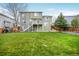 Expansive backyard with a lush lawn, mature tree and wooden fence at 3865 Rawhide Cir, Castle Rock, CO 80104