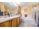 Bright bathroom with double sinks, wooden cabinets, and a separate shower and tub at 3865 Rawhide Cir, Castle Rock, CO 80104