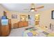 Sunny bedroom featuring a ceiling fan, wooden dresser, and doorway leading to the bathroom at 3865 Rawhide Cir, Castle Rock, CO 80104