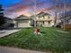 Charming two-story home with well-manicured lawn and cozy front porch under a stunning sunset sky at 3865 Rawhide Cir, Castle Rock, CO 80104