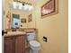 Compact half bathroom featuring a toilet, sink, and wall mirror with decorative accents at 3865 Rawhide Cir, Castle Rock, CO 80104