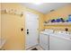 Functional laundry room with washer, dryer, storage shelf, and door to the outside at 3865 Rawhide Cir, Castle Rock, CO 80104