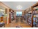 Cozy study featuring wood floors, two large wooden bookcases, a window, and seating at 3865 Rawhide Cir, Castle Rock, CO 80104