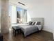 Cozy bedroom features a plush bed with gray bedding, a cityscape view, and sleek modern design at 55 W 12Th Ave # 510, Denver, CO 80204