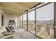 This balcony features floor to ceiling windows, a sofa, and a view of the surrounding landscaping at 7865 E Mississippi Ave # 602, Denver, CO 80247
