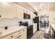 Bright kitchen with white cabinets, black appliances, and an adjacent dining area at 7865 E Mississippi Ave # 602, Denver, CO 80247