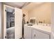 Functional laundry room with washer, dryer, ironing board, and storage space at 7865 E Mississippi Ave # 602, Denver, CO 80247
