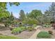 Beautiful community pond with mature trees and landscaping creates a peaceful outdoor space at 7865 E Mississippi Ave # 602, Denver, CO 80247