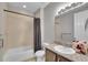 This well-lit bathroom has a shower/tub combo, granite counters and vanity, and a large mirror at 9635 Bellaire Ln, Thornton, CO 80229