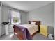 This cozy bedroom features a natural wood bed frame, a window with curtains, and a cute yellow nightstand at 9635 Bellaire Ln, Thornton, CO 80229