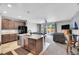 Open-concept kitchen featuring granite countertops, dark wood cabinets, and seamless flow to the living area at 9635 Bellaire Ln, Thornton, CO 80229