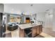 Open-concept kitchen and living area featuring modern appliances, granite counters, and a cozy sitting area at 9635 Bellaire Ln, Thornton, CO 80229