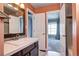 Stylish bathroom with elegant vanity, modern fixtures, and access to the adjacent bedroom and shower at 1907 S Balsam St, Lakewood, CO 80227
