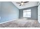 Spacious bedroom with high ceiling, plush carpeting, ceiling fan and large window allowing plenty of natural light at 1907 S Balsam St, Lakewood, CO 80227
