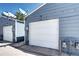 Detached two-car garage with white doors, and the house number displayed above at 1907 S Balsam St, Lakewood, CO 80227