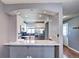 Bright updated kitchen features modern white cabinets, stainless appliances and breakfast bar with marble countertop at 1907 S Balsam St, Lakewood, CO 80227