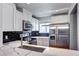 Charming kitchen features white cabinets, stainless steel appliances, and marble counter top with black subway tile backsplash at 1907 S Balsam St, Lakewood, CO 80227