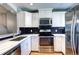 Modern kitchen features white cabinets, stainless steel appliances, and stylish black subway tile backsplash at 1907 S Balsam St, Lakewood, CO 80227