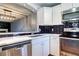 Updated kitchen features white cabinets, stainless steel appliances, and stunning black subway tile backsplash at 1907 S Balsam St, Lakewood, CO 80227