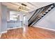 Open-concept living room featuring hardwood floors, adjacent kitchen, and staircase at 1907 S Balsam St, Lakewood, CO 80227