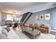 Bright, open-concept living room and dining area with modern finishes and staircase at 1907 S Balsam St, Lakewood, CO 80227