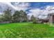 Spacious green backyard with mature trees, enclosed by a wood fence at 7425 S Dexter St, Centennial, CO 80122