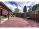Backyard deck overlooks a brick-lined flower bed and a wood fence with foliage at 7425 S Dexter St, Centennial, CO 80122